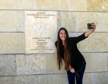 Beckah Shae, a Nashville-based singer-songwriter popular on Christian radio, snapped selfies with the dedication plaque outside the U.S. Embassy to Israel in Jerusalem. (Daniel Estrin/NPR)