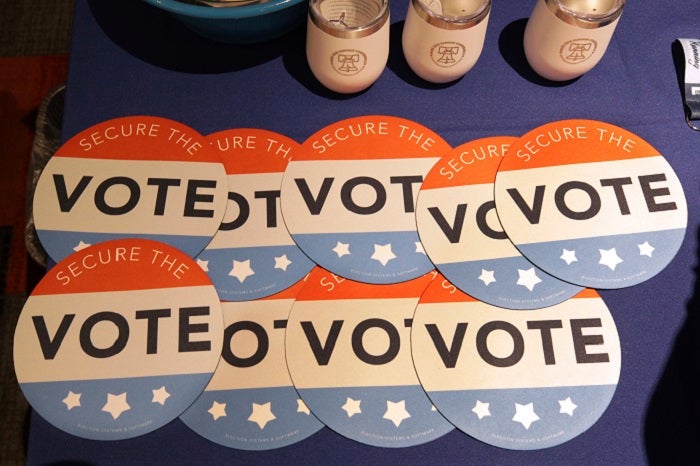 FILE - In this July 14, 2018, file photo, computer mouse pads with Secure the Vote logo on them are seen on a vendor's table at a convention of state secretaries of state in Philadelphia. As alarms blare about Russian interference in U.S. elections, the Trump administration is facing criticism that it has no clear national strategy to protect the country during the upcoming midterms and beyond. Both Republicans and Democrats have criticized the administration’s response as fragmented, without enough coordination across federal agencies. (AP Photo/Mel Evans, File)