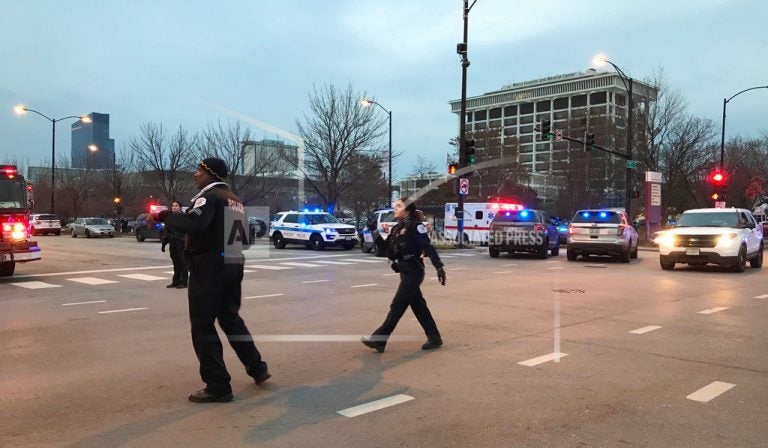 Chicago Police officers walk outside Mercy Hospital on the city's South Side where authorities say four people, including the gunman, have died in a shooting Monday. (AP Photo/Amanda Seitz)