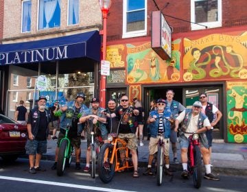 Members of the the Jersey Devils Bicycle Club stood outside of Tattooed Mom's on South Street Sunday. (Brad Larrison for WHYY)
