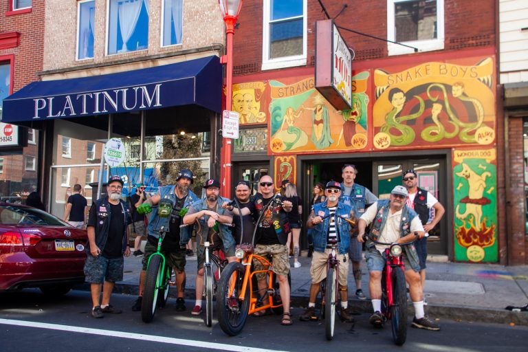 Members of the the Jersey Devils Bicycle Club stood outside of Tattooed Mom's on South Street Sunday. (Brad Larrison for WHYY)