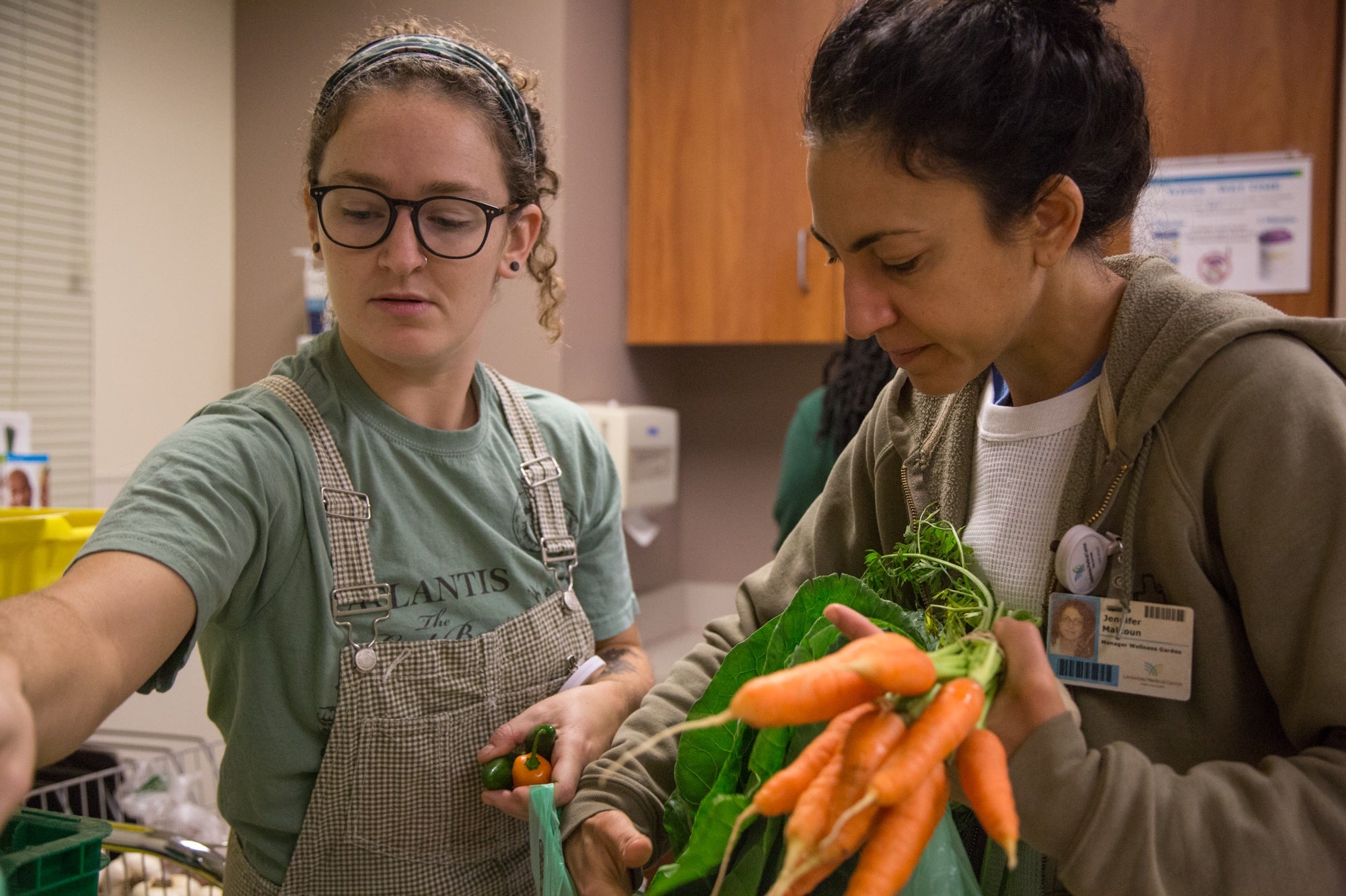 Deirdre Sheehy and Jen Malkoun organize the produce they've brought from the Wellness Farm to make it easier for doctors to pass out the vegetables to patients.