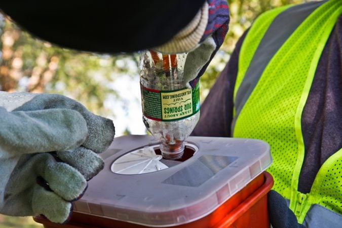 City workers and community groups work to clean up McPherson Square and the area around it. They were safely disposing of used needles. (Kimberly Paynter/WHYY)