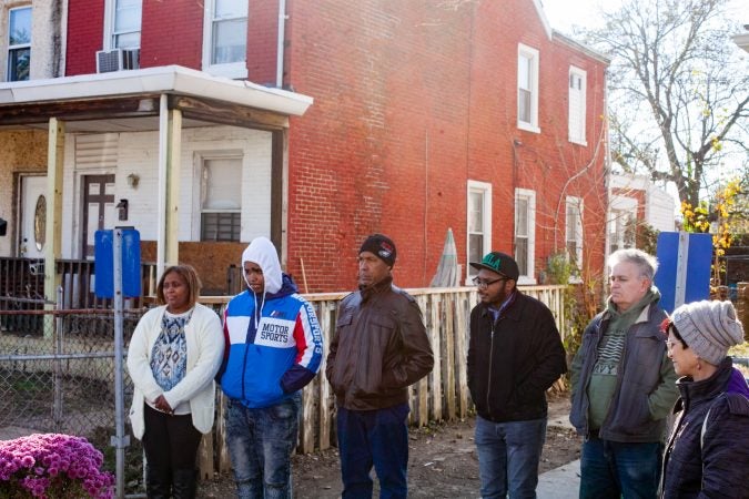 The Mella family, left, stand near their home during a gathering of Tacony residents and neighbors who came out on Saturday to show support for the family who received a threatening and racist letter earlier this month. (Brad Larrison for WHYY)