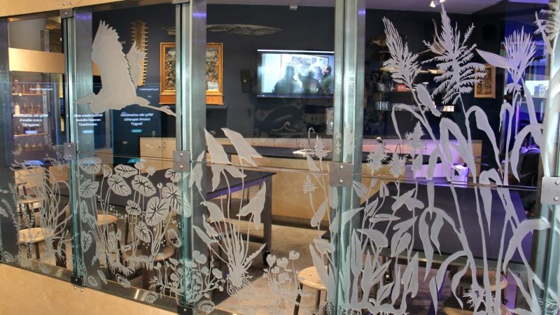 Visitors are encouraged to make rubbings of the etched glass wall depicting different components of life in the river. (Emma Lee/WHYY)