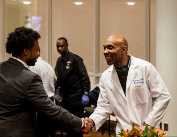 Anesthesiologist Kevin Guynn M.D greets a pre-med student at Temple University's An Evening with Black Men in Medicine event. (Brad  Larrison for WHYY)