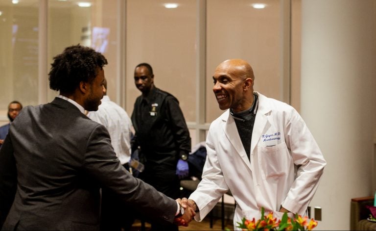 Anesthesiologist Kevin Guynn M.D greets a pre-med student at Temple University's An Evening with Black Men in Medicine event. (Brad  Larrison for WHYY)