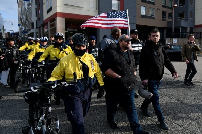 When escorted away from the rally police officers form a barrier between counter-protesters on the left, and a group who participated in the 