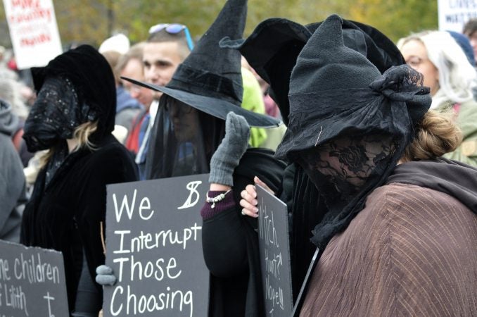 Counter-protesters dressed in witches attire are among a group facing the 