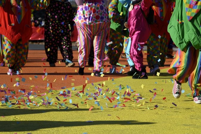 Confetti is picked up by the wind as a group of clowns marches past the cameras at the Art Museum steps, during the 99th annual Thanksgiving Day Parade in Philadelphia. (Bastiaan Slabbers for WHYY)