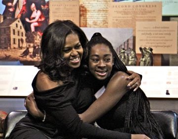 Michelle Obama embraces Nariah, a Philadelphia high school sophomore, during a surprise visit to the African American Museum in Philadelphia. A dozen girls in the beGirl.world program, which encourages African American girls to travel, were treated to an intimate question and answer session with the former First Lady.