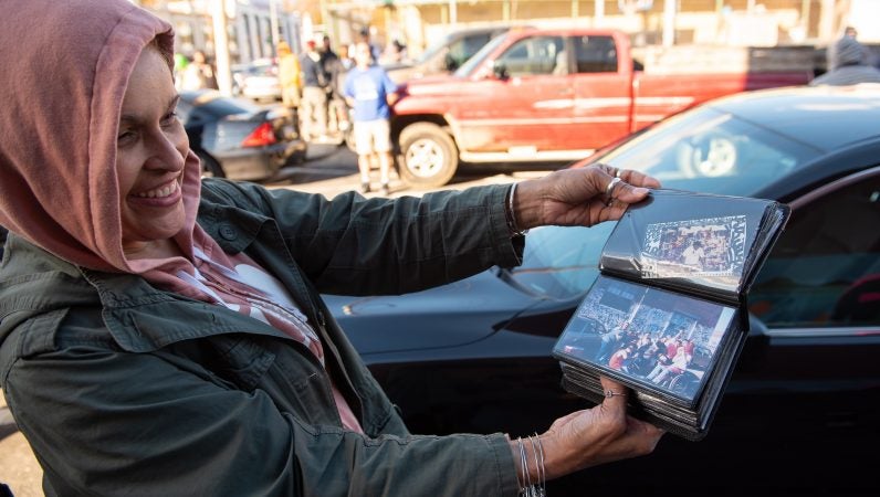 Migdalia Nazario, sister to the late graffiti writer Karaz, flips through photos of the Philadelphia legend on Saturday, November 3, 2018. (Kriston Jae Bethel for WHYY)