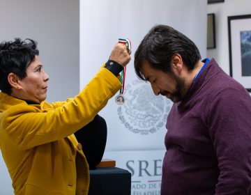 Alicia Kerber Palma le entregó a Obed Arango una pequeña medalla en una cinta verde, roja y blanca. Al estilo de CCATE, Arango dijo que el premio pertenece a la comunidad.. (Kriston Jae Bethel for WHYY)