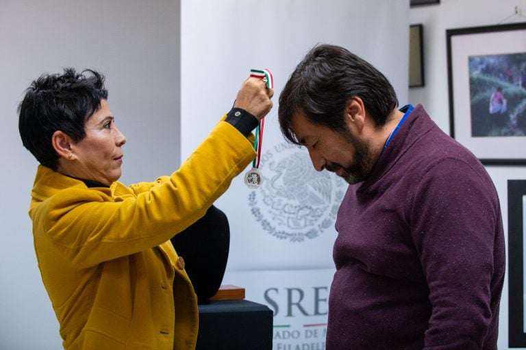 Alicia Kerber Palma le entregó a Obed Arango una pequeña medalla en una cinta verde, roja y blanca. Al estilo de CCATE, Arango dijo que el premio pertenece a la comunidad.. (Kriston Jae Bethel for WHYY)