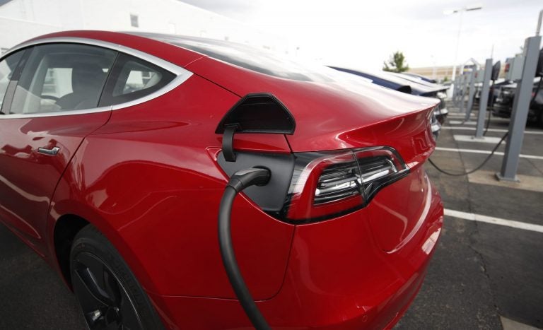 In this Sunday, July 8, 2018, photograph, 2018 Model 3 sedans charge while on display outside a Tesla showroom in Littleton, Colo. (David Zalubowski/AP Photo)