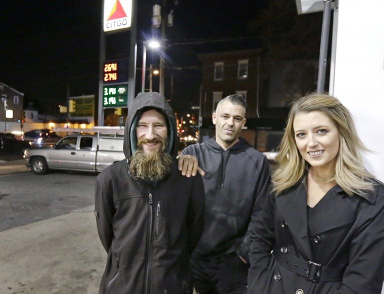 Johnny Bobbitt Jr., (left), Kate McClure, and Mark D'Amico pose at a gas station