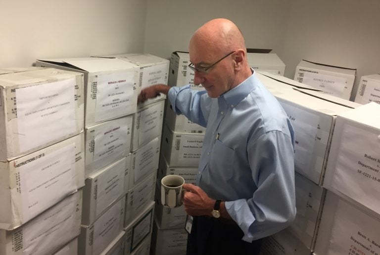 In this Aug. 7, 2018, photo, Mark Robbins, the sole member of the Merit Systems Protection Board, walks through the supply closet, pointing to boxes full of cases, in his office in Washington. Robbins reads through federal workplace disputes, analyzes the cases, marks them with notes and logs his legal opinions. He then passes them along to nobody. He’s the only member of a three-member board that legally can’t operate until the president and Congress give him at least one colleague.  (Juliet Linderman/AP Photo)