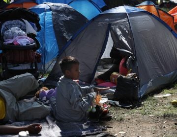 A migrant child sits outside a tent, taking shelter at the Jesus Martinez stadium in Mexico City, Tuesday, Nov. 6, 2018. Humanitarian aid converged around the stadium in Mexico City where thousands of Central American migrants winding their way toward the United States were resting Tuesday after an arduous trek that has taken them through three countries in three weeks. (Marco Ugarte/AP Photo)