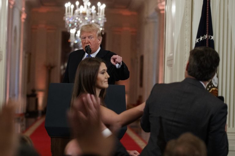 President Donald Trump looks on as a White House aide attempts to take away a microphone from CNN journalist Jim Acosta during a news conference in the East Room of the White House, Wednesday, Nov. 7, 2018, in Washington. (Evan Vucci/AP Photo)