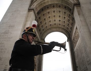 Military officer Garcia plays the original Armistice bugle from 1918 under the Arc de Triomphe Sunday, Nov. 11, 2018 in Paris. More than 60 heads of state and government are in France for the Armistice ceremonies at the Tomb of the Unknown Soldier in Paris on the 11th hour of the 11th day of the 11th month, exactly a century after the armistice. (AP Photo/Francois Mori, Pool)