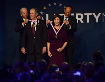 Former U.S. Vice President Joe Biden, from left, bestows a medal on former U.S. President George Bush as former first lady Laura Bush has the same bestowed by Doug DeVos, executive committee chairman for the National Constitution Center, at the National Constitution Center, Sunday, Nov. 11, 2018 in Philadelphia. Both received the 30th annual Liberty Medal, an honor given to those who are committed to freedom and human rights globally. (AP Photo/Corey Perrine)