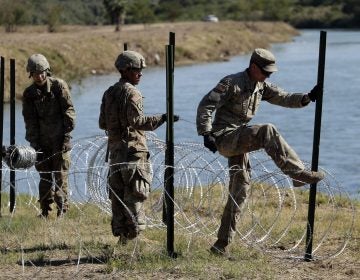 Members of the U.S. military install multiple tiers of concertina wire along the banks of the Rio Grande near the Juarez-Lincoln Bridge at the U.S.-Mexico border, Friday, Nov. 16, 2018, in Laredo, Texas. (AP Photo/Eric Gay)