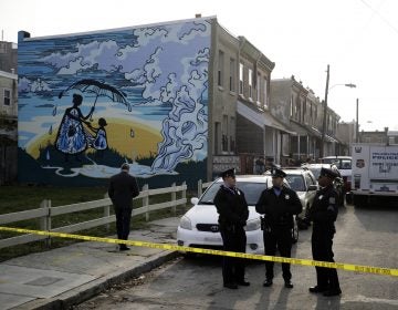 Police gather at the scene of a fatal shooting in the center row home in Philadelphia, Monday, Nov. 19, 2018. Police say two men and two women have been found shot and killed in a basement in Philadelphia. (AP Photo/Matt Rourke)