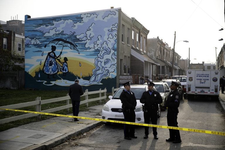 Police gather at the scene of a fatal shooting in the center row home in Philadelphia, Monday, Nov. 19, 2018. Police say two men and two women have been found shot and killed in a basement in Philadelphia. (AP Photo/Matt Rourke)