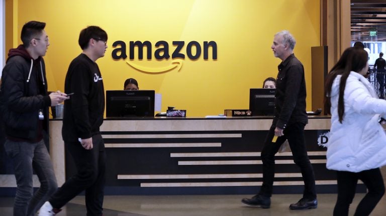  Employees walk through a lobby at Amazon's Seattle headquarters. (Elaine Thompson/AP Photo)