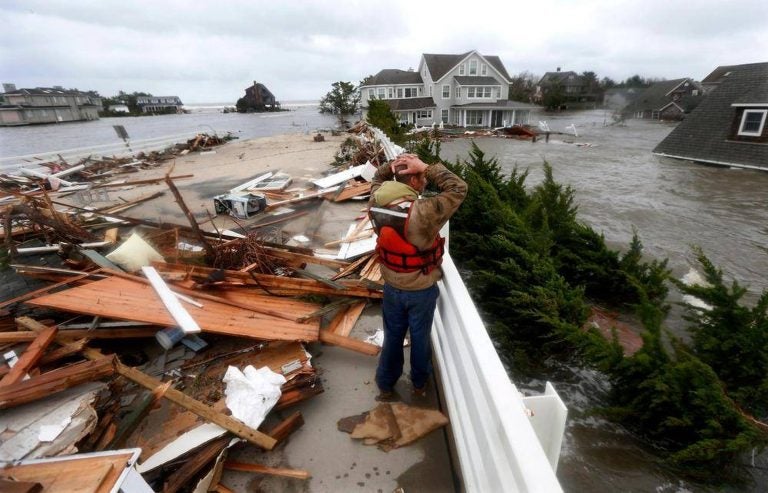 Brian Hajeski, 41, of Brick, N.J., reacts as he looks at debris of a home that washed up on to the Mantoloking Bridge the morning after superstorm Sandy rolled through in Mantoloking, N.J., Oct. 30, 2012. (Julio Cortez/AP Photo)