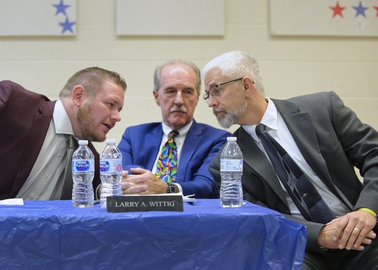 Joe Egan, right, a representative of The Buckeye Firearm Foundation, at a Tamaqua School Board meeting in November 2018. Board member Nicholas Boyle, left, and School Board President Larry Wittig, confer with him. (Matt Smith for Keystone Crossroads)