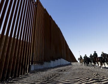 Mounted Border Patrol agents ride along a newly fortified border wall structure in Calexico, Calif. Funding for the border wall is one of a number of administration priorities that may face challenges if the Democrats flip the House. (Gregory Bull/AP)