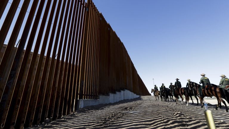 Mounted Border Patrol agents ride along a newly fortified border wall structure in Calexico, Calif. Funding for the border wall is one of a number of administration priorities that may face challenges if the Democrats flip the House. (Gregory Bull/AP)