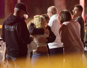 People comfort each other outside a bar in Thousand Oaks, Calif., where a gunman opened fire and killed 12.