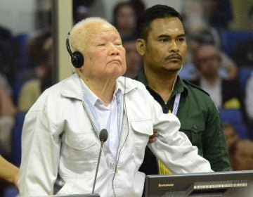 Khieu Samphan, (left), former Khmer Rouge head of state, stands at the dock in a court room during a hearing at the U.N.-backed war crimes tribunal in Phnom Penh, Cambodia, on Friday. (Nhet Sok/AP/Extraordinary Chambers in the Courts of Cambodia)