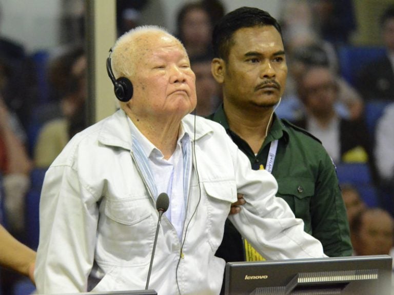 Khieu Samphan, (left), former Khmer Rouge head of state, stands at the dock in a court room during a hearing at the U.N.-backed war crimes tribunal in Phnom Penh, Cambodia, on Friday. (Nhet Sok/AP/Extraordinary Chambers in the Courts of Cambodia)