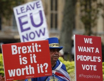 Demonstrators hold placards in London on Friday. (Alastair Grant/AP)