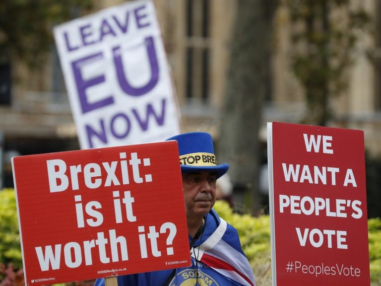 Demonstrators hold placards in London on Friday. (Alastair Grant/AP)