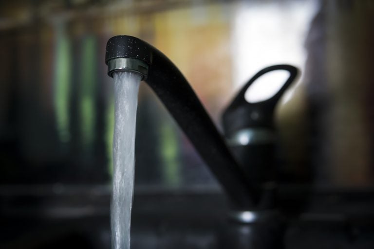 Water pours from a faucet.