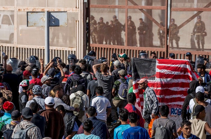 dpatop - 26 November 2018, Mexico, Tijuana: Migrants face security forces on the border with the USA. In the Mexican border town of Tijuana, numerous migrants have tried to illegally cross the border to the USA. Photo by: Omar Martinez/picture-alliance/dpa/AP Images
