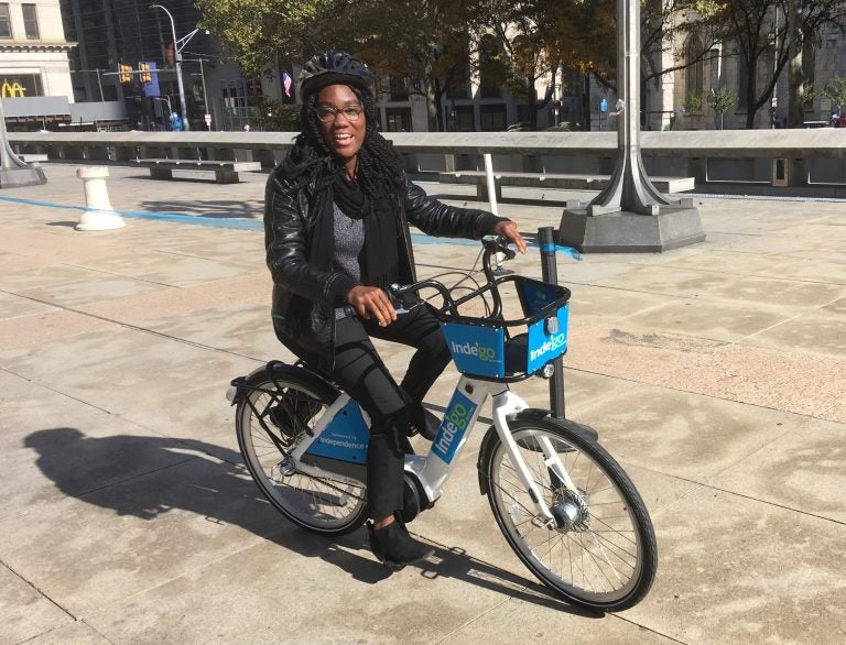 Chamarra McCrorie gives Indego's new e-bikes a test ride on Thomas Paine Plaza. (Jim Saksa/WHYY)