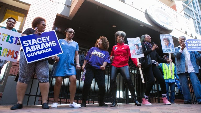 Georgia voters and supporters dance and sing during a 