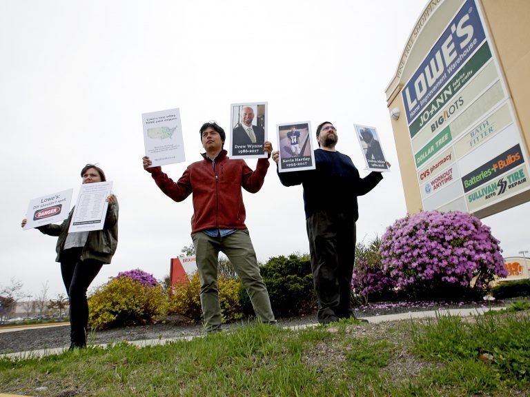 Protestors holding pictures of people who died from use of paint removers, including Drew Wynne, protest outside a Portland, Maine, Lowe's store on May 10, 2018. They were trying to persuade the retailer to stop selling paint strippers containing methylene chloride. (Ben McCanna/Portland Press Herald via Getty Images)