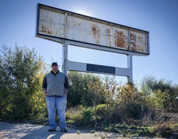 Don Skidmore stands in front of a sign for United Auto Workers Local 735, the union chapter he represented as president when he was a General Motors employee. (Ari Shapiro/NPR)
