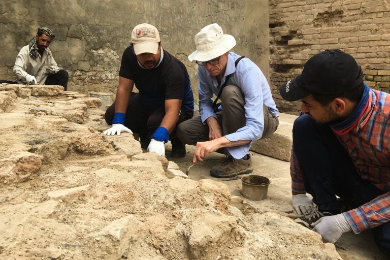 American conservationist Jeff Allen (center) directs Iraqi technicians laying mortar between ancient bricks at the site of Babylon. (Jane Arraf/NPR)