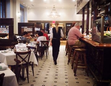 A member of the staff walks through Luke, one of the restaurants still owned by John Besh, on St. Charles Avenue in New Orleans. (Emily Kask for NPR)