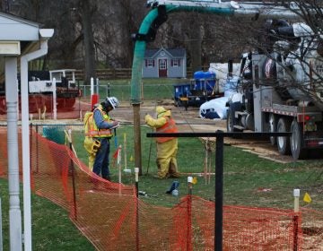 In this photo from May 2018, pipeline workers probe the ground on Lisa Drive in West Whiteland Township where sinkholes have developed as a result of the Mariner East 2 construction. (Jon Hurdle/StateImpact Pennsylvania)