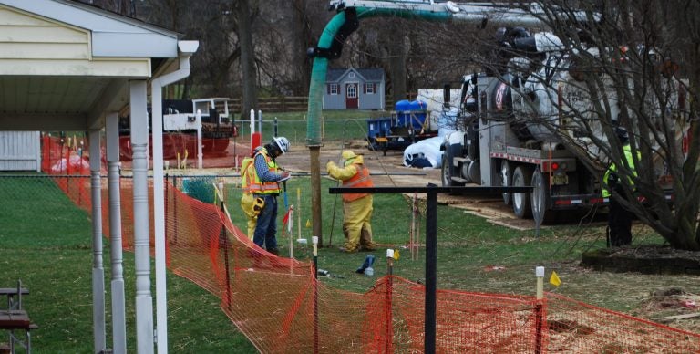 In this photo from May 2018, pipeline workers probe the ground on Lisa Drive in West Whiteland Township where sinkholes have developed as a result of the Mariner East 2 construction. (Jon Hurdle/StateImpact Pennsylvania)