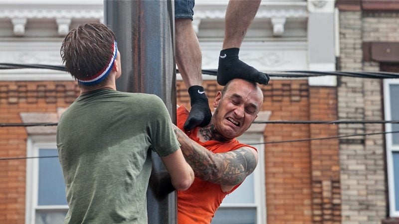 Teammates compete in the greased pole-climbing contest at the Ninth Street Italian Market Festival on May 20, 2018. (Emma Lee/WHYY)