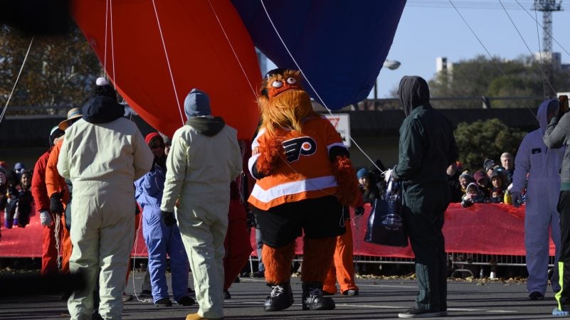 Flyers mascot Gritty helps balloon handlers during the 99th annual Thanksgiving Day Parade in Center City Philadelphia. (Bastiaan Slabbers for WHYY)